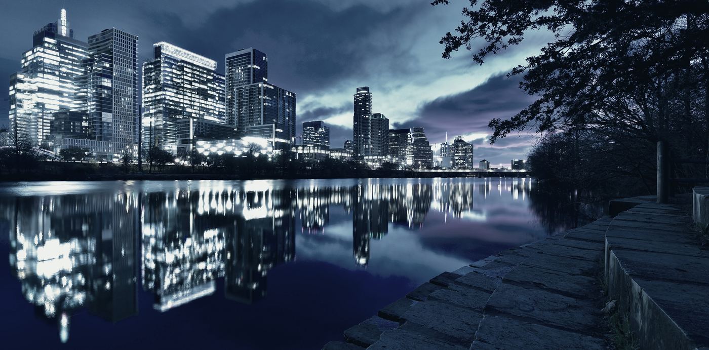 Downtown Austin's towers reflected in Lady Bird Lake before sunrise.